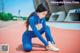 A woman tying up her shoes on a track.