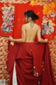 A woman in a red kimono with a tattoo on her back.