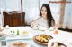 A woman sitting at a table with a plate of food.