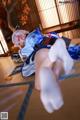 A woman in a blue and white outfit laying on the floor.