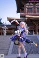 A woman in a blue and white outfit holding a sword.