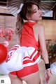 A woman in a red and white outfit holding an umbrella.