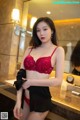 a woman in a red bra and black panties standing in front of a mirror