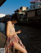 A woman sitting on a dock next to a body of water.