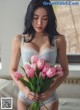 A woman holding a bunch of pink tulips in her hands.