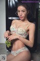 A woman in a bikini holding a bunch of grapes.