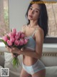 A woman holding a bunch of pink tulips in her hand.