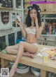 A woman sitting on top of a wooden table eating food.