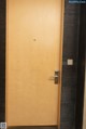 A wooden door with a metal handle in a room.