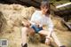 A woman sitting on top of a pile of hay.