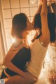 A couple of women kissing in front of a mirror.