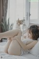 a woman laying on top of a bed next to a window