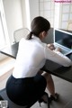 A woman sitting at a desk using a laptop computer.