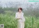 A woman in a white dress standing in a field of flowers.