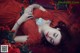 A woman in a red dress laying on a bed of roses.