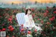 A woman sitting in a chair in a field of roses.