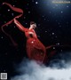 A woman in a red dress is dancing in the snow.