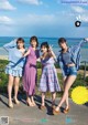 A group of young women standing next to each other on a road.