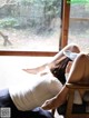 A woman laying on a chair in front of a window.