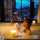 A woman sitting in a bathtub with candles in front of a window.