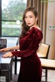 a woman in a red dress standing next to a table