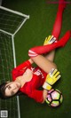 A woman laying on the ground with a soccer ball.