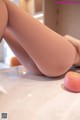 A woman laying on a table next to an apple.