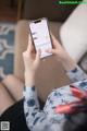 A woman sitting on a couch holding a cell phone.