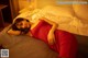 A woman in a red dress laying on a bed.