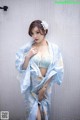 A woman in a blue and white kimono posing for a picture.