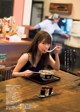 A woman sitting at a table eating a bowl of food.