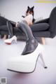 A woman in black and white boots sitting on a couch.