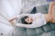 A woman laying on top of a gray couch.