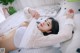 A woman laying on a bed in a white lingerie.