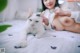 A woman laying on a bed next to a white cat.