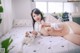 A woman laying on a bed with a white cat.