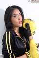 A woman in a black jacket and yellow boxing gloves.