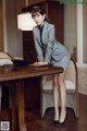 A woman in a business suit leaning over a desk.