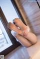 A woman in stockings and stockings sitting on a window sill.