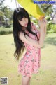 A woman in a pink dress holding a yellow umbrella.