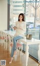 A woman sitting at a table reading a book.