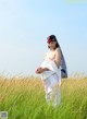 A woman standing in a field of tall grass.