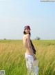 A woman standing in a field of tall grass.