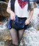 A woman in a school uniform is standing in the water.