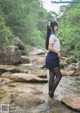 A woman in a school uniform standing in a stream.