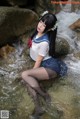 A woman in a sailor outfit is sitting in the water.