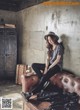 A woman sitting on top of a brown couch.