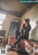 A woman sitting on top of a brown couch.