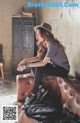 A woman sitting on top of a brown leather couch.