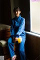 A woman in a blue tracksuit holding a yellow and white ball.